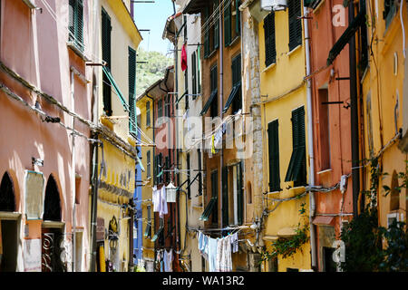 Porto Venere in Italia, strette tipiche città vecchia strada con case colorate e clotheslines, selezionata la messa a fuoco e profondità di campo ridotta Foto Stock