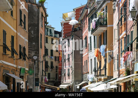 Restringere vivace strada con case colorate e panni appesi nella città vecchia di Vernazza e le Cinque Terre in Liguria, Italia Foto Stock