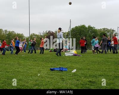 3° livellatrici giocando una partita di pallavolo al di fuori su di un caldo e nuvoloso giorno di maggio, 2019. Foto Stock