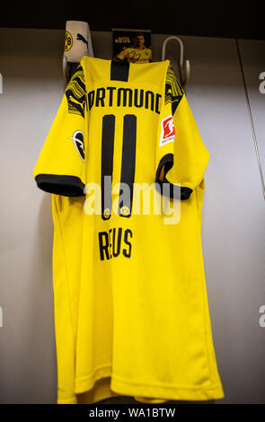 Dortmund, Germania. 14 Ago, 2019. Calcio: Bundesliga. Nel team di cabina del Borussia Dortmund il jersey di Dortmund il Marco Reus è appeso alla parete e la fascia del capitano appeso accanto ad esso su un gancio. Credito: Guido Kirchner/dpa/Alamy Live News Foto Stock