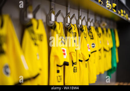 Dortmund, Germania. 14 Ago, 2019. Calcio: Bundesliga. Nel team di cabina del Borussia Dortmund il jersey di Dortmund il Marco Reus è appeso alla parete e la fascia del capitano appeso accanto ad esso su un gancio. Credito: Guido Kirchner/dpa/Alamy Live News Foto Stock