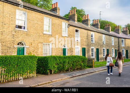 Cambridge, Regno Unito - Giugno 2019: giovani donne matura a piedi nella parte anteriore del tenements tradizionali case in stile vittoriano a Cambridge nel Regno Unito. Foto Stock