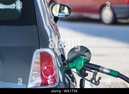 Riempire con benzina il pompaggio del gas, di pompaggio ugello carburante benzina a gas station sfondo. Foto Stock