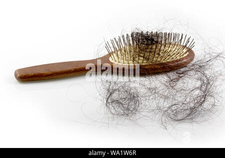 Pila di donne la perdita di capelli problema, i peli cadono con spazzola rosa su sfondo bianco. Foto Stock