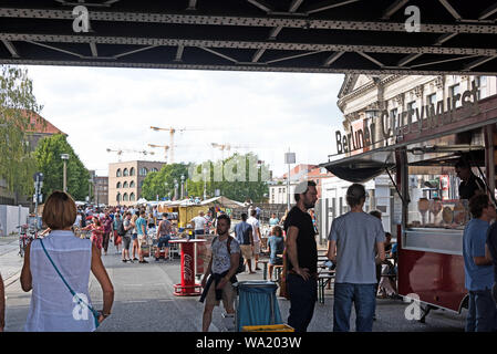 Gli amanti dello shopping a una pressione di stallo Currywurst sotto il ponte Stadtbahn presso gli antichi e prenota mercato vicino al Bode Museum di Berlino, Germania. Foto Stock