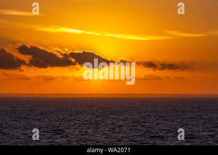 Le turbine eoliche sulla costa italiana al tramonto con incredibile cielo nuvoloso, Puglia, Italia Foto Stock