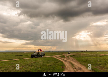 Ol Pejeta conservancy, contea di Laikipia, Kenya - Giugno 12th, 2019: distante safari tour in open-top marcia carrello lungo la pista sterrata sul Ol Pejeta Conservan Foto Stock