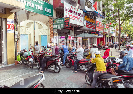 La città di Ho Chi Minh, Vietnam: persone sulla moto attende la fine delle lezioni per prelevare i bambini, a Nguyen Thai Binh scuola primaria cancelli di ingresso. Foto Stock