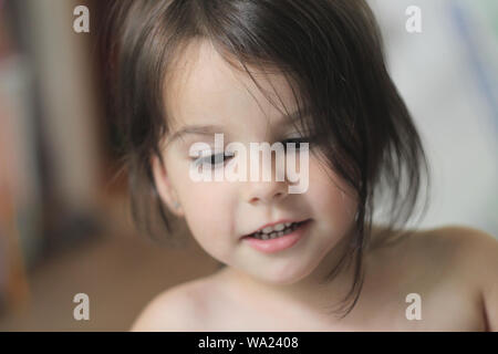 Ritratto di un bel po' di sorridente ragazza con capelli lunghi marrone e lo sguardo verso il basso Foto Stock