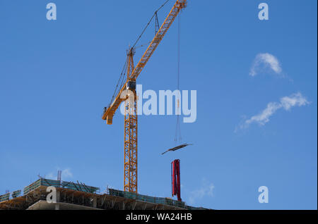 Una gru di lavoro contro un cielo blu brillante Foto Stock