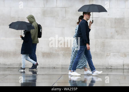 Londra, Regno Unito. 16 Ago, 2019. Le persone sono considerate sotto gli ombrelloni durante la pioggia a Londra. Credito: Steve Taylor/SOPA Immagini/ZUMA filo/Alamy Live News Foto Stock