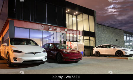 Ingresso della Tesla Showroom e Centro di Servizio con Tesla modello 3 e due Tesla Model X è parcheggiato di fronte. Foto Stock