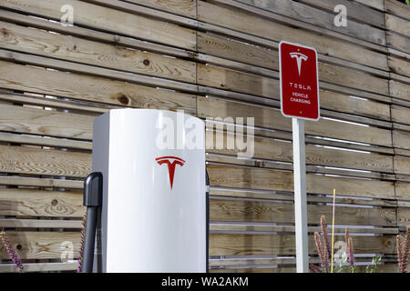 Tesla Urban Supercharger luccicante di notte. Foto Stock