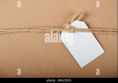 White paper tag regalo su marrone cartoon sfondo della carta Foto Stock