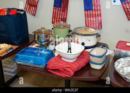 Ottenere il cibo insieme e lo staging di setup per il giorno di indipendenza il barbecue presso l'ufficio. Foto Stock