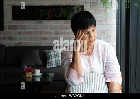 Vecchia donna che soffre di mal di testa e stress, emicrania, problema di salute concetto Foto Stock
