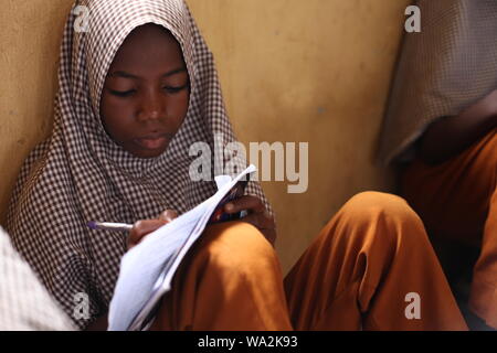 Gli studenti che frequentano la classe in Nigeria la scuola primaria in camera inadeguata Foto Stock