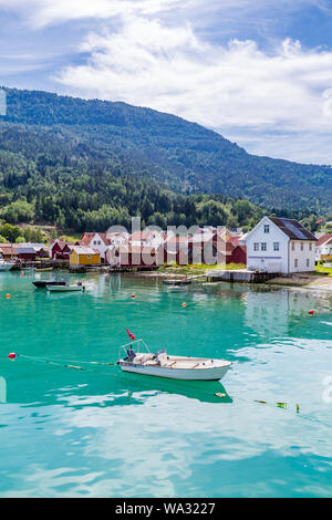 Vista a Solvorn, un pittoresco paesino con bianche case di legno lungo Lustrafjorden su un giorno di estate in Sogn og Fjordane contea in Norvegia. Foto Stock