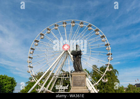 Ginevra, Svizzera - Luglio, 08, 2019: ruota panoramica Ferris con la bandiera svizzera sul suo centro nei pressi del Lago di Ginevra. Foto Stock