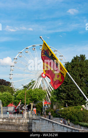 Ginevra, Svizzera - Luglio, 08, 2019: ruota panoramica Ferris con la bandiera svizzera sul suo centro nei pressi del Lago di Ginevra. Foto Stock
