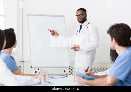 African-american cardiologo dando lezione per stagisti in clinica Foto Stock