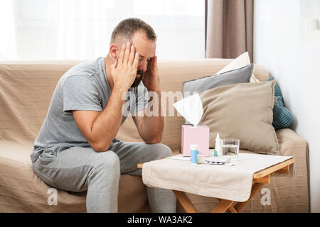 Concetto di alta temperatura. L'uomo si sente male. Come ridurre la febbre. Sintomi e cause freddi. Malato con influenza. Febbre alta e mal di testa Foto Stock