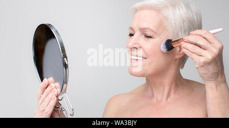 Ritratto di bella donna senior fare il trucco. Foto Stock