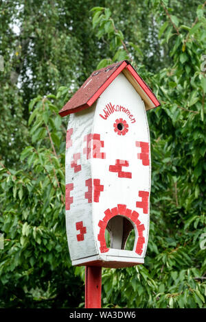 Rosso-bianco birdhouse in un giardino tedesco Foto Stock