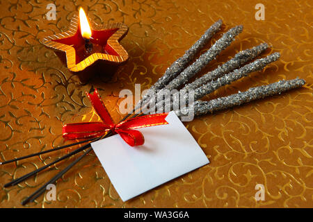 Phooljhadi and diya with a blank card isolated on yellow background Stock Photo