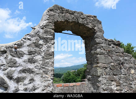 Vista attraverso una finestra di rovina per la bella Toscana paesaggio estivo e il Castello di Malgrate, da virgoletta, un antico villaggio di montagna, distretto o Foto Stock