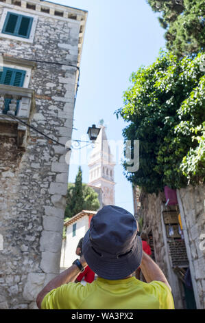 Vista posteriore del vecchio turistico giallo che indossa la t-shirt e cappuccio facendo le foto del famoso sito Foto Stock