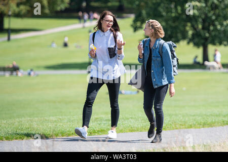 Per coloro che godono di un periodo di sole su Primrose Hill a Londra, come docce blustery sono attesi in tutto il Regno Unito nei prossimi giorni mentre le speranze di un Bank Holiday ondata di caldo sono state distrutte da forecasters. Foto Stock