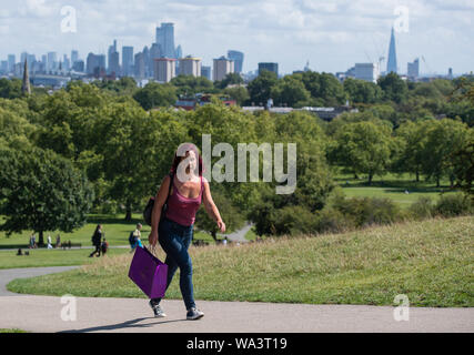 Per coloro che godono di un periodo di sole su Primrose Hill a Londra, come docce blustery sono attesi in tutto il Regno Unito nei prossimi giorni mentre le speranze di un Bank Holiday ondata di caldo sono state distrutte da forecasters. Foto Stock