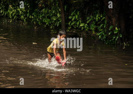 Kolkata, India. 17 Ago, 2019. Un bambino gioca in corrispondenza di una zona di saturo di acqua in Kolkata, India, il 17 agosto, 2019. Credito: Tumpa Mondal/Xinhua/Alamy Live News Foto Stock