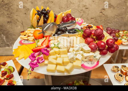 Frutta fresca fragole, uva e melone su spiedini con vari formaggi morsi - solo boccone che serve - disposti party finger food Foto Stock