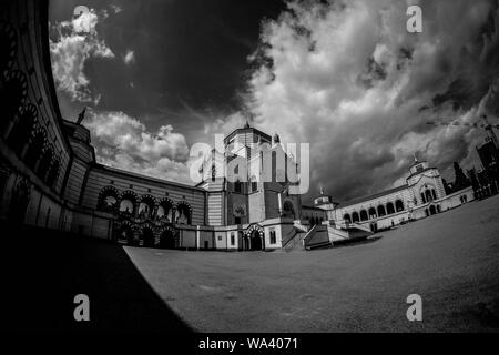 Foto ad angolo basso di una casa cimitero sotto una nuvolosa cielo in bianco e nero Foto Stock