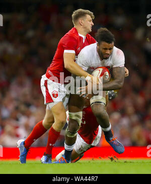 L'Inghilterra del Courtney Lawes (centro) viene affrontato dal Galles Dan Biggar e dispositivo di sovrapposizione di Aronne durante l'amichevole internazionale presso il Principato Stadium di Cardiff. Foto Stock