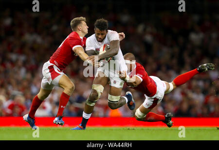 L'Inghilterra del Courtney Lawes (centro) viene affrontato dal Galles Dan Biggar e dispositivo di sovrapposizione di Aronne durante l'amichevole internazionale presso il Principato Stadium di Cardiff. Foto Stock