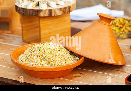 Tajine di verdure con cous cous su un tavolo di legno. Foto Stock