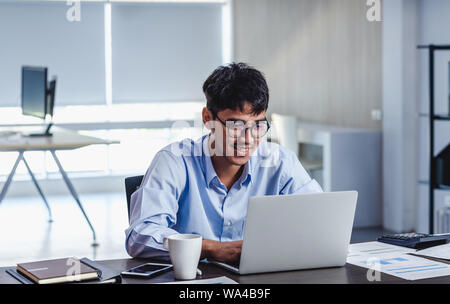 Imprenditore asiatico di Woking con il computer portatile e il foglio di lavoro sulla scrivania in ufficio.workflow digitale business online il concetto di stile di vita Foto Stock