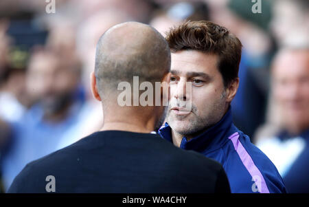 Manchester City manager Pep Guardiola (sinistra) saluta Tottenham Hotspur manager Mauricio Pochettino durante il match di Premier League al Etihad Stadium e Manchester. Foto Stock