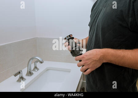 Riparazione in bagno a casa idraulico installando nuove mani di scarico lavoratore close up Foto Stock