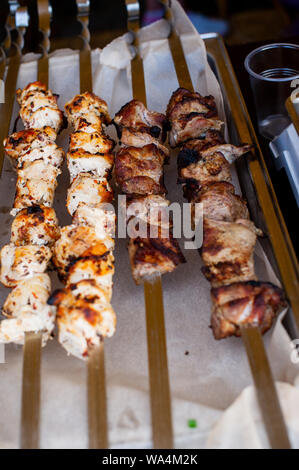 Spiedino di carne. Gli spiedini su spiedini. La carne di maiale cotta sul fuoco. Abbiamo mangiato il grill. Street cibi preparati al momento. Il cibo sulla pergamena di cibo. Bella kebab. Natura Foto Stock