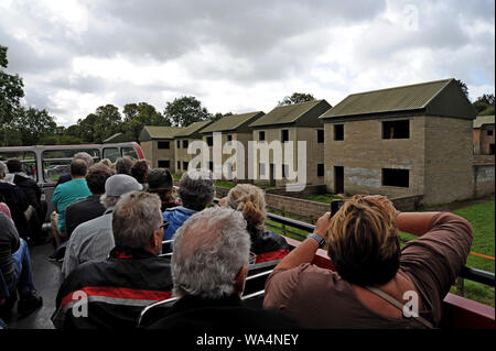 Warminster, Wiltshire, Regno Unito. Il 17 agosto 2019. Open top passeggeri di un autobus su un viaggio su Salisbury Plain pass Ministero della Difesa urban assault case di formazione. Oltre 30 gli autobus londinesi, prevalentemente Routemasters classic, raccogliere in Warminster per eseguire un servizio di autobus per il "villaggio perduto" di Imber su Salisbury Plain. Il villaggio fu requisita per la seconda guerra mondiale ai fini della formazione nel 1943 ed è rimasta una parte di MOD basi di formazione da sempre, tranne che per un open day per anno. G.P.Essex/Alamy Live News Foto Stock