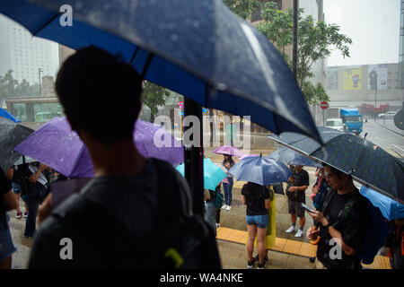Hong Kong Cina. 17 Ago, 2019. I partecipanti di una dimostrazione di stare di fronte ad un parco con gli ombrelli sotto la pioggia durante un rally. In Hong Kong vi sono state massicce proteste per più di due mesi. Le dimostrazioni sono state innescate da un disegno di legge del governo - ora in attesa - per l'estradizione di sospetti criminali in Cina. Credito: Gregor Fischer/dpa/Alamy Live News Foto Stock