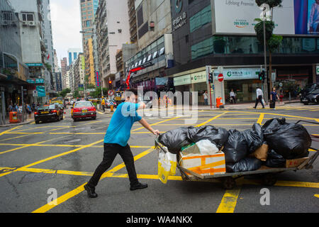Hong Kong Cina. 17 Ago, 2019. Un fornitore spinge un carro con merci confezionate su un incrocio stradale nel distretto centrale. Credito: Gregor Fischer/dpa/Alamy Live News Foto Stock