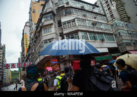 Hong Kong Cina. 17 Ago, 2019. I partecipanti a una dimostrazione a piedi passato negozi chiusi e gli edifici residenziali in Hong Kong Kowloon distretto. In Hong Kong vi sono state massicce proteste per più di due mesi. Le dimostrazioni sono state innescate da un disegno di legge del governo - ora in attesa - per l'estradizione di sospetti criminali in Cina. Credito: Gregor Fischer/dpa/Alamy Live News Foto Stock