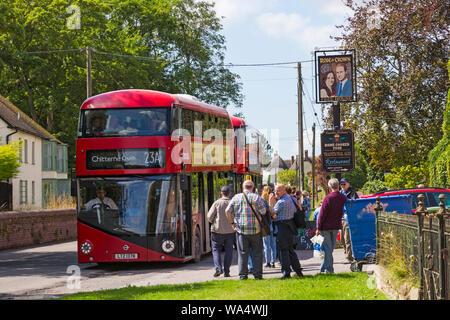 Tilshead, Wiltshire, Regno Unito. 17 ago 2019. Trasportati indietro ai giorni passati! Migliaia di visitatori a sfruttare al massimo le opportunità di scoprire il perso il villaggio di Imber su uno speciale Open Day, evento Imberbus che opera da più di 25 vecchi e nuovi autobus Routemaster a prendere i visitatori a Imber e in altri luoghi sulla pianura, compresi Tilshead. Gli autobus passano attraverso Tilshead sotto lo sguardo di Kate e al Rose & Crown free house pub! I visitatori in attesa a bordo dell'autobus. Credito: Carolyn Jenkins/Alamy Live News Foto Stock