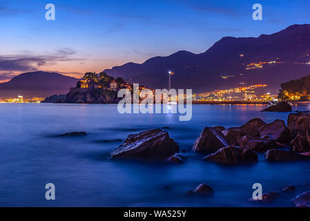 Vista di Sveti Stefan dalla spiaggia in Monenegro al tramonto Foto Stock