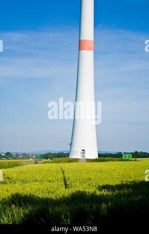 Il trattore su un campo con le turbine eoliche Foto Stock